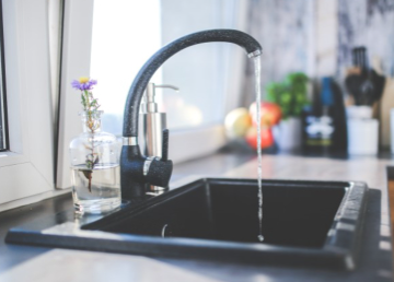 Modern kitchen sink with water flowing.